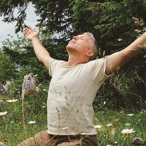 Yogalehrer praktiziert eine Herzöffnungsübung in der blühenden Natur