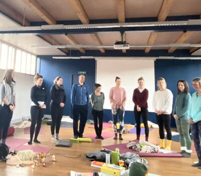 Yogaklassesteht im Kreis bei der Abschlussrunde der Yogalehrer Ausbildung