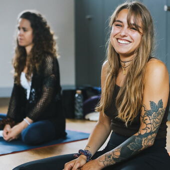 Strahlendes Lächeln einer jungen Frau in der Yogaausbildung