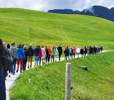 Gruppe wandert im Gänsemarsch durch die Berglandschaft in der Schweiz